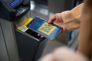 Håndscanning af en digital QR-billet på en smartphone ved en automatiseret gate-terminal