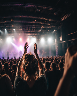 Fans på en livekonsert med scenen upplyst bakom sig